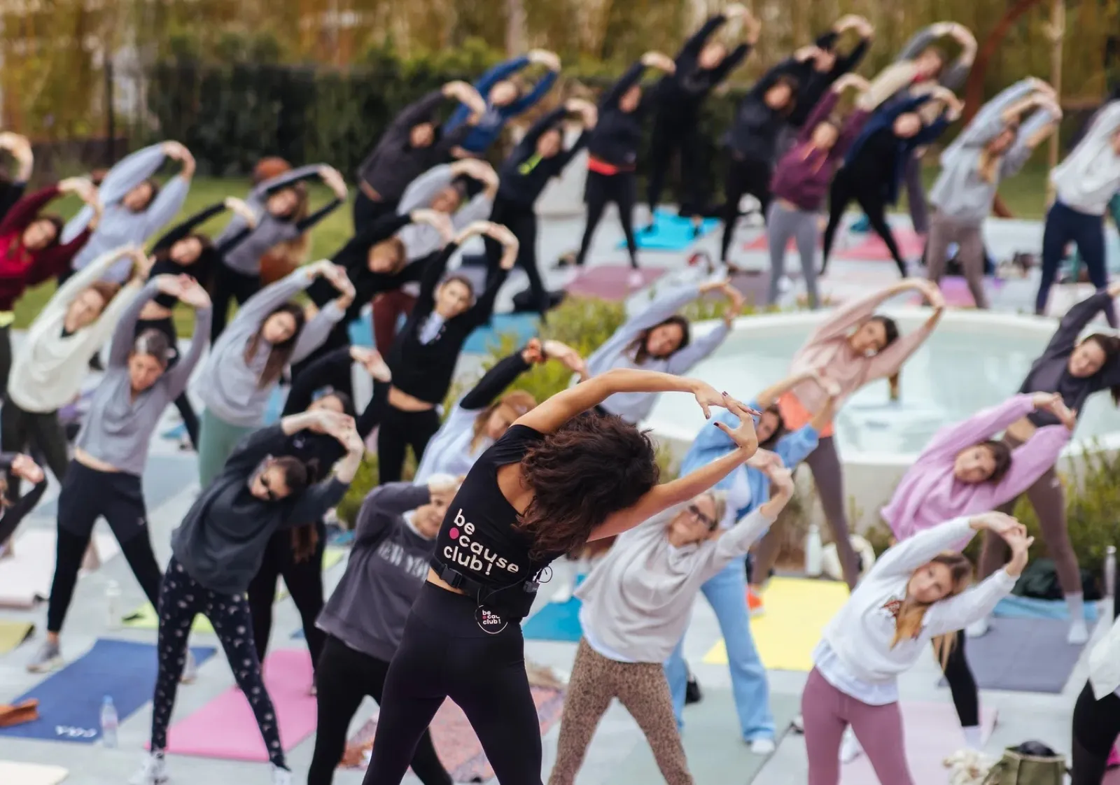 Un grand cours de Pilates en plein air : des dizaines de participantes s’étirent sur leurs tapis